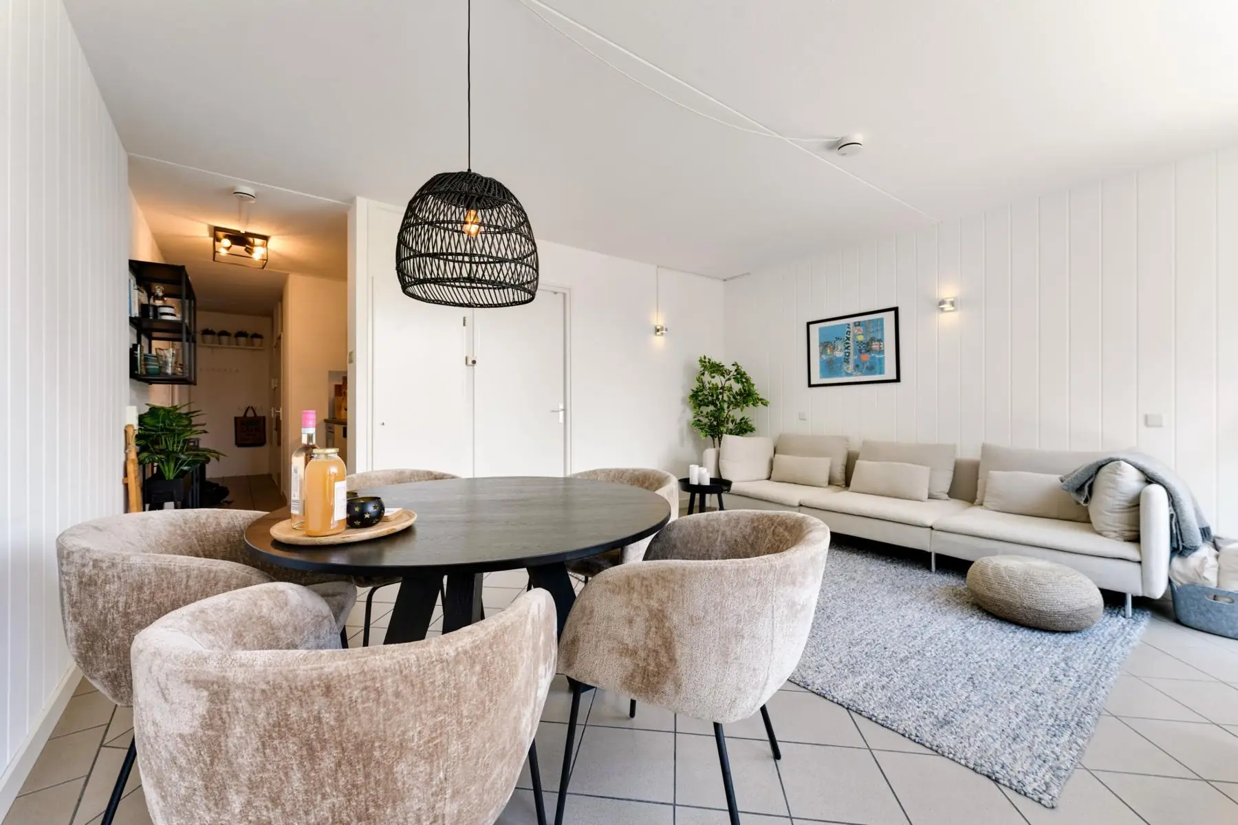 Eettafel met zachte stoelen onder een rieten hanglamp