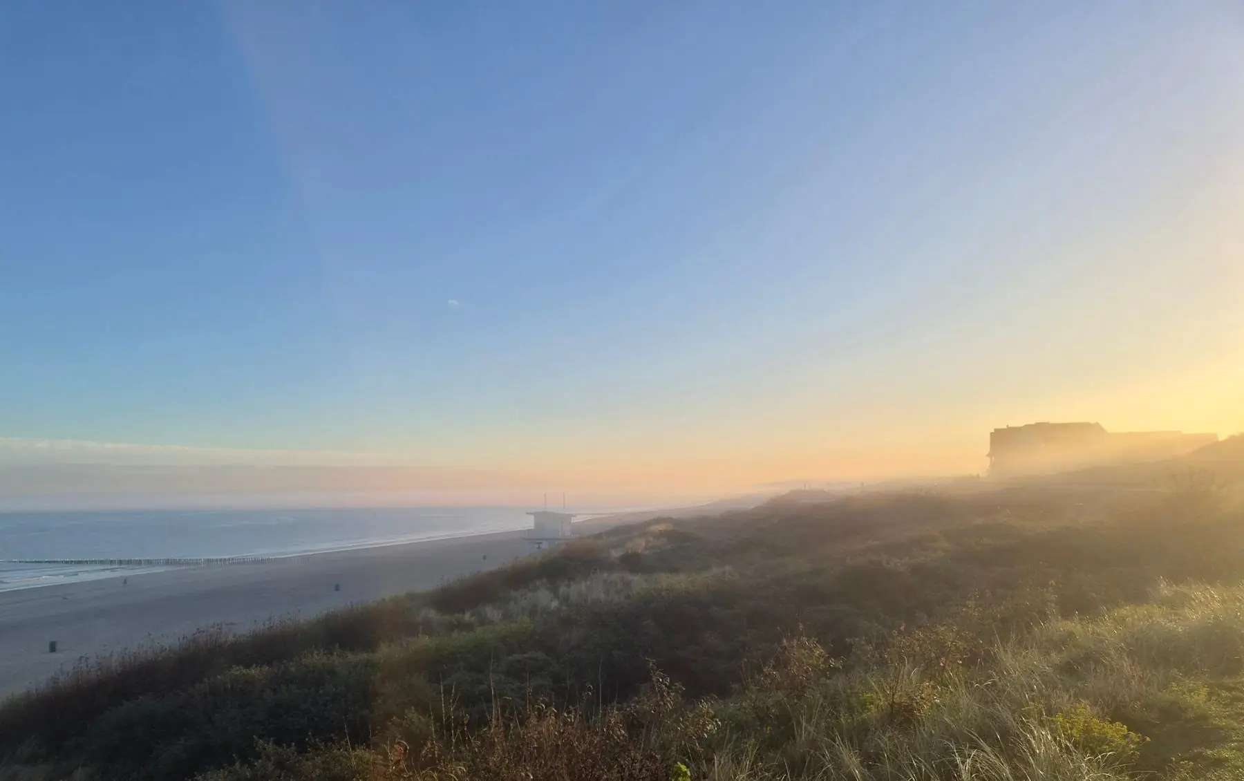 Gouden ochtendlicht over de duinen en het strand